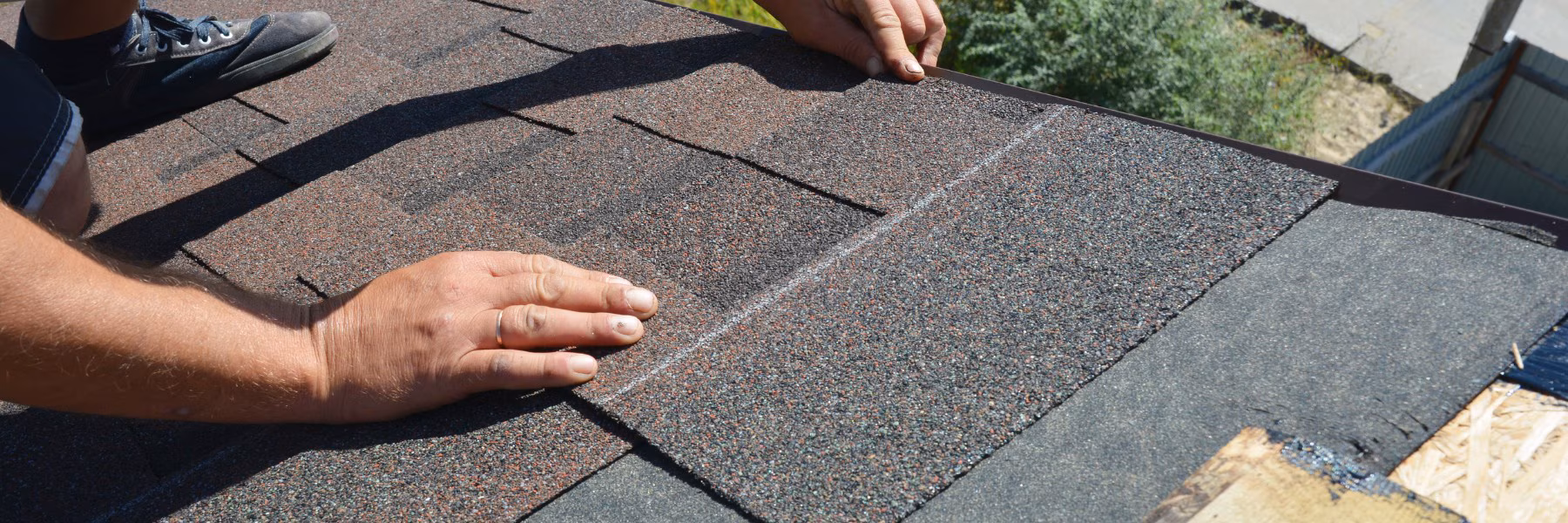 Roofer checking shingles by hand